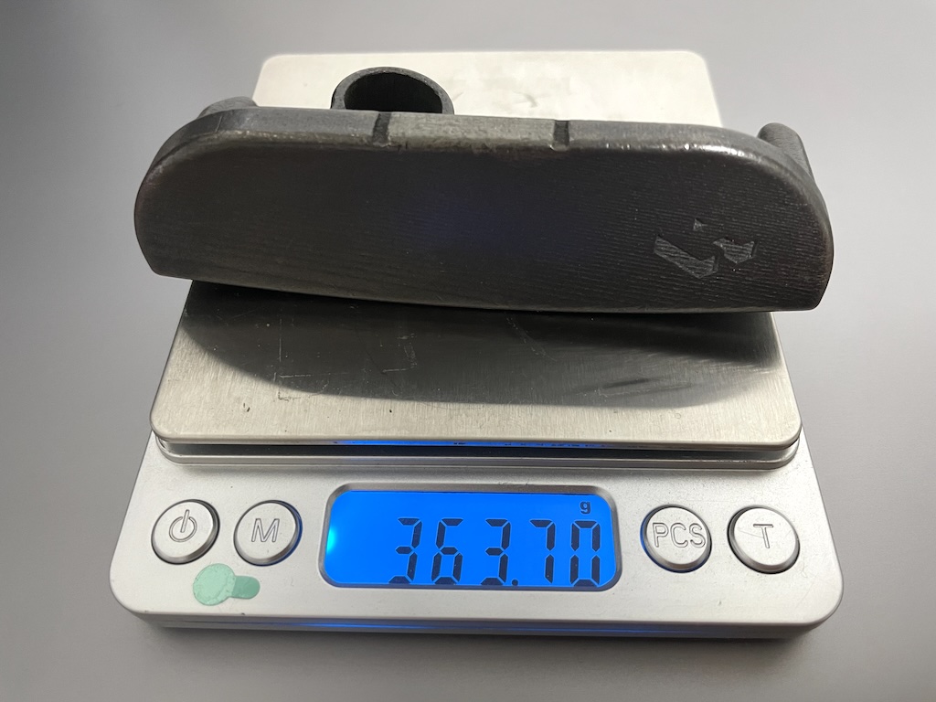 A putter head resting on a digital scale reading 363.7 grams